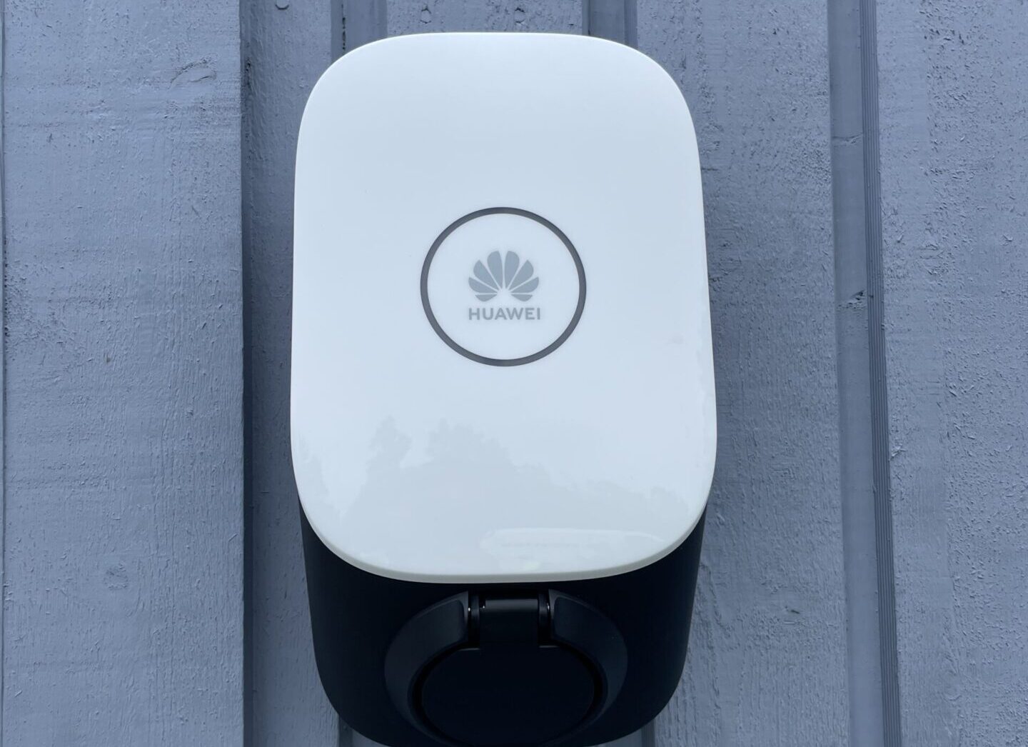 En vit dosa av märket HUAWEI som sitter på en husvägg.