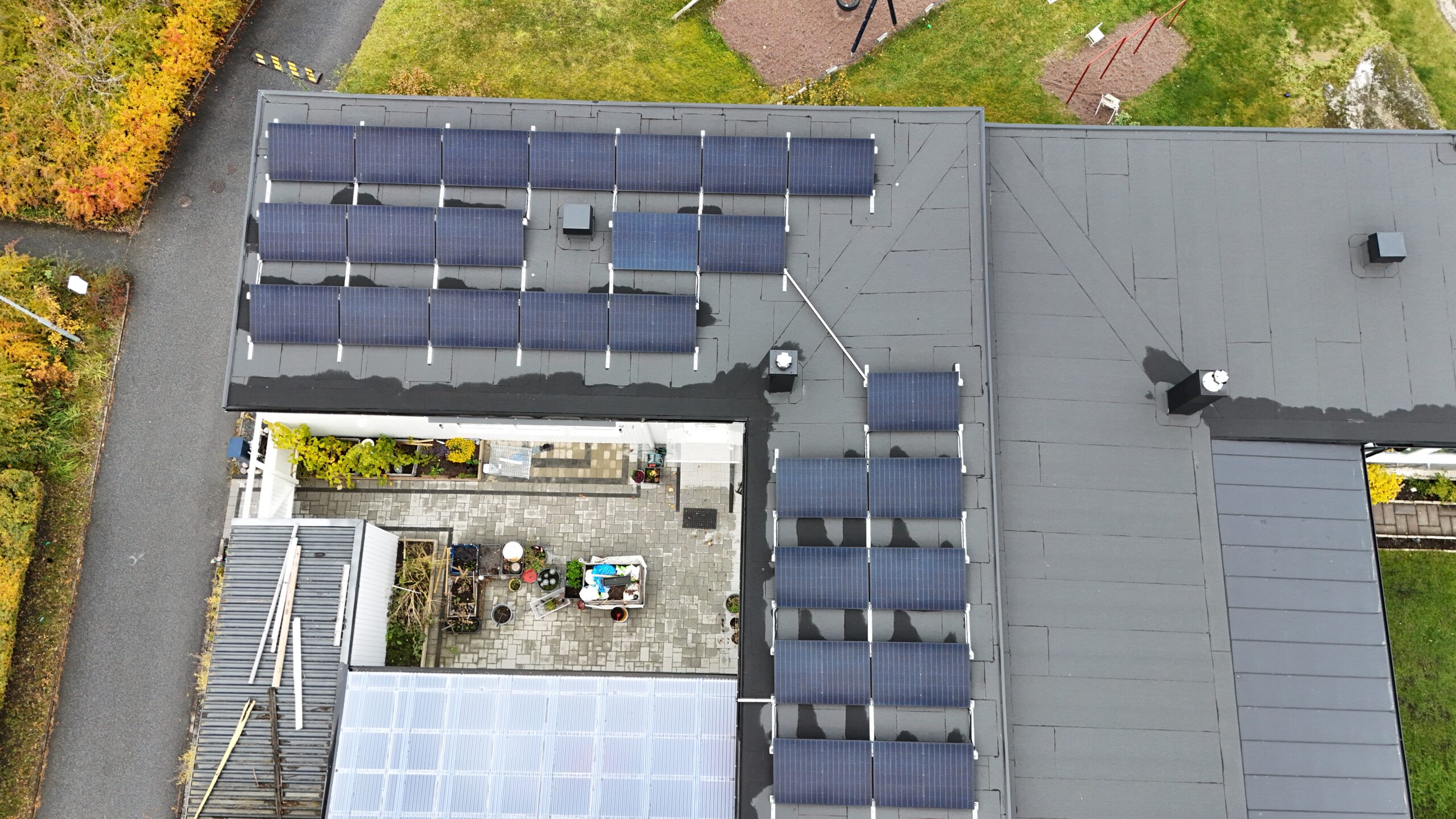 Fågelvy ovanför ett radhus med solceller på papptaket.