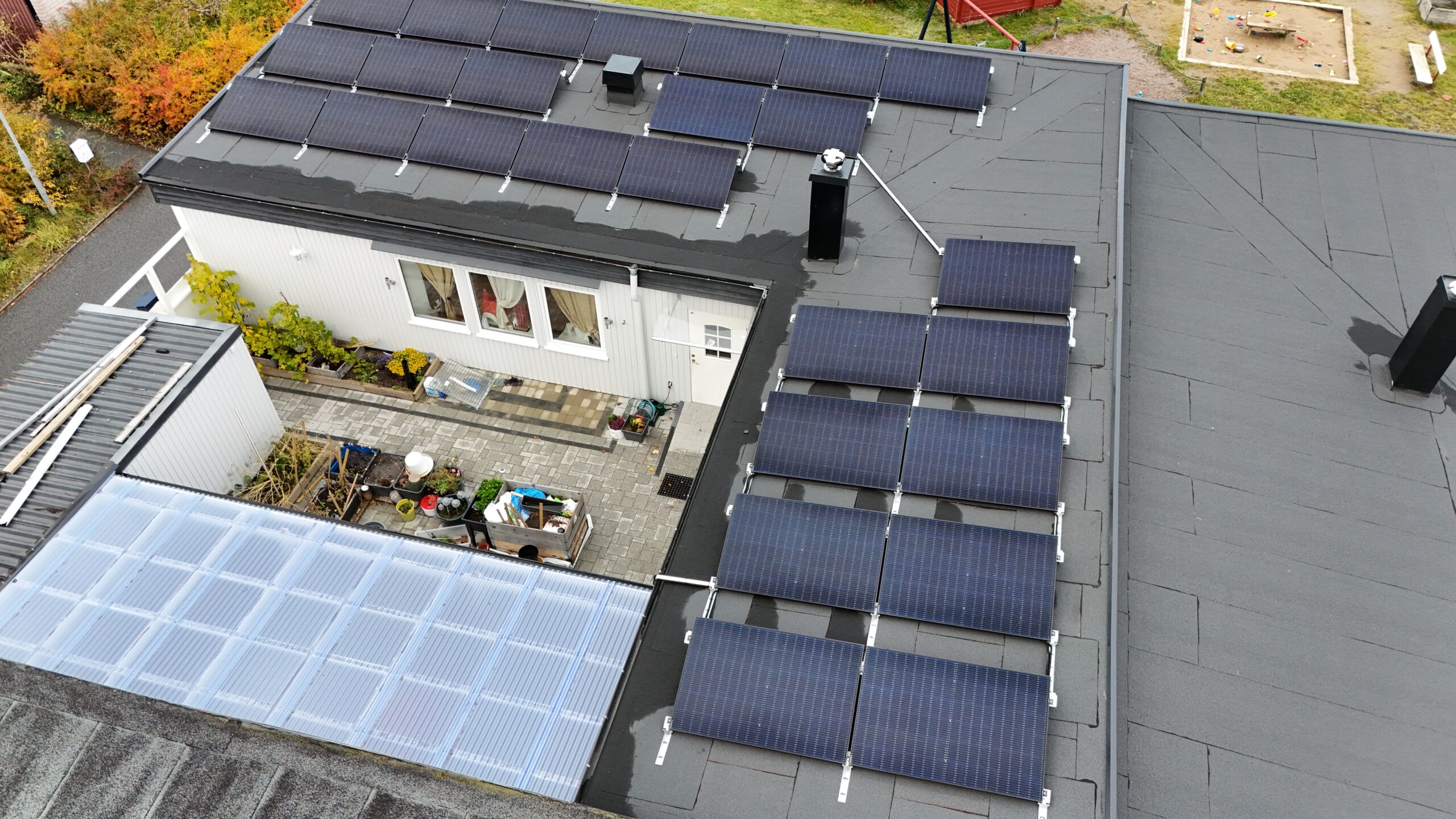 Fågelvy ovanför ett radhus med solceller på papptaket.