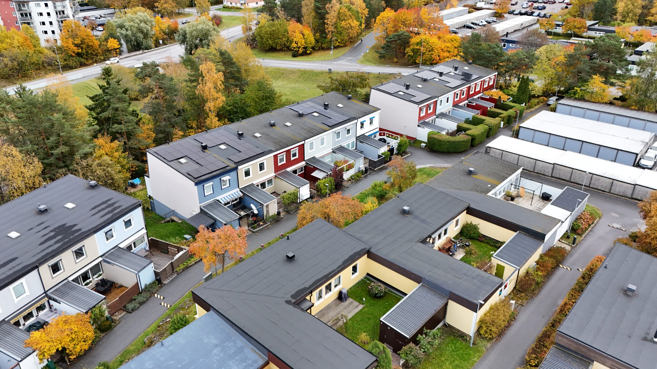 Fågelvy ovanför ett radhusområde med solceller på papptaket.