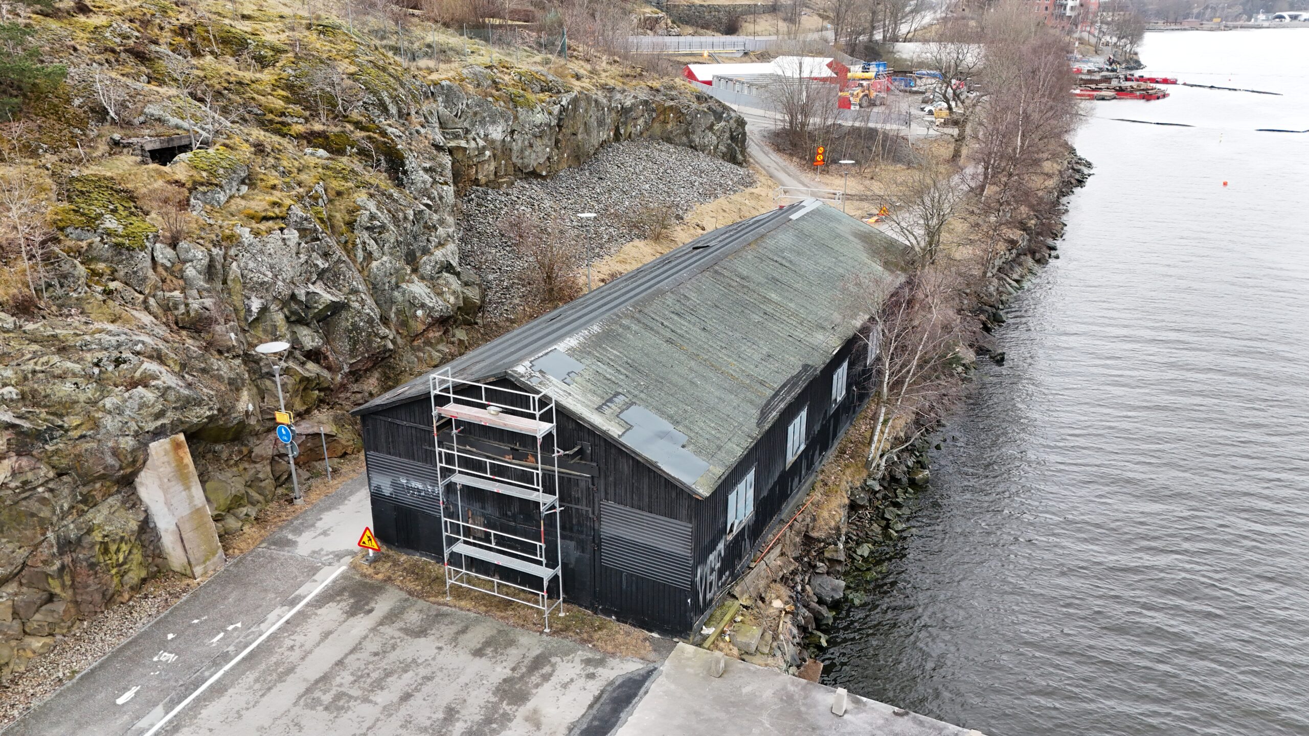 Fågelvy över ett hustak med slitet och missfärgat papptak.