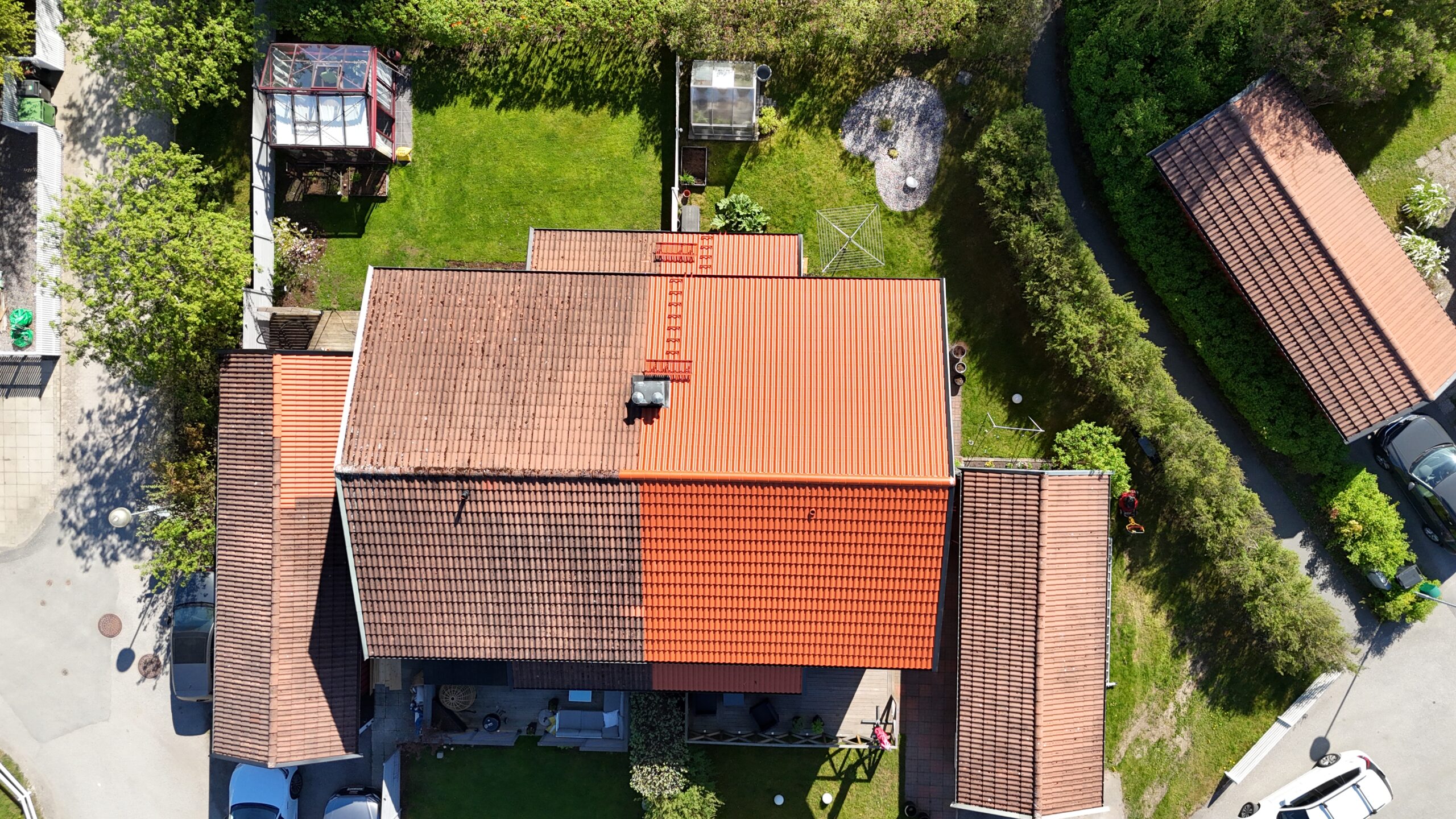 Fågelvy över ett rött radhus. Hustaket är omlagt på halv sidan med nya tegelpannor.