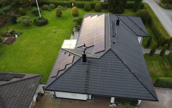 Fågelvy över ett hus med omlagt tak. Taket är av betongpannor och har solceller på sig.